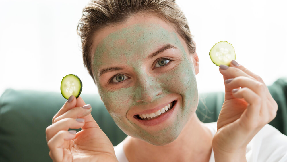 Beautiful woman with facial mask and cucumber slices