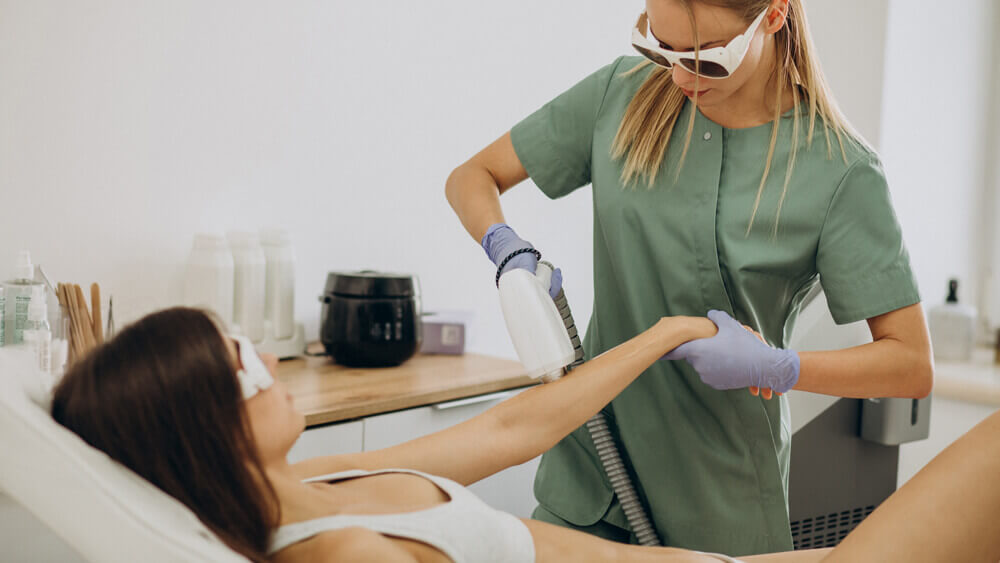 Diode laser hair removal getting done on a woman's arm in a beauty clinic