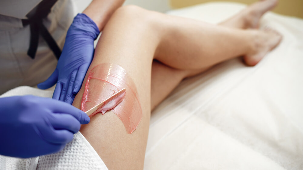 Waxing on woman's leg in a beauty clinic