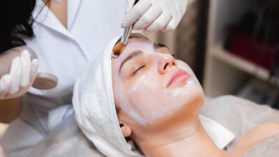 Beautician doing facial on patient face