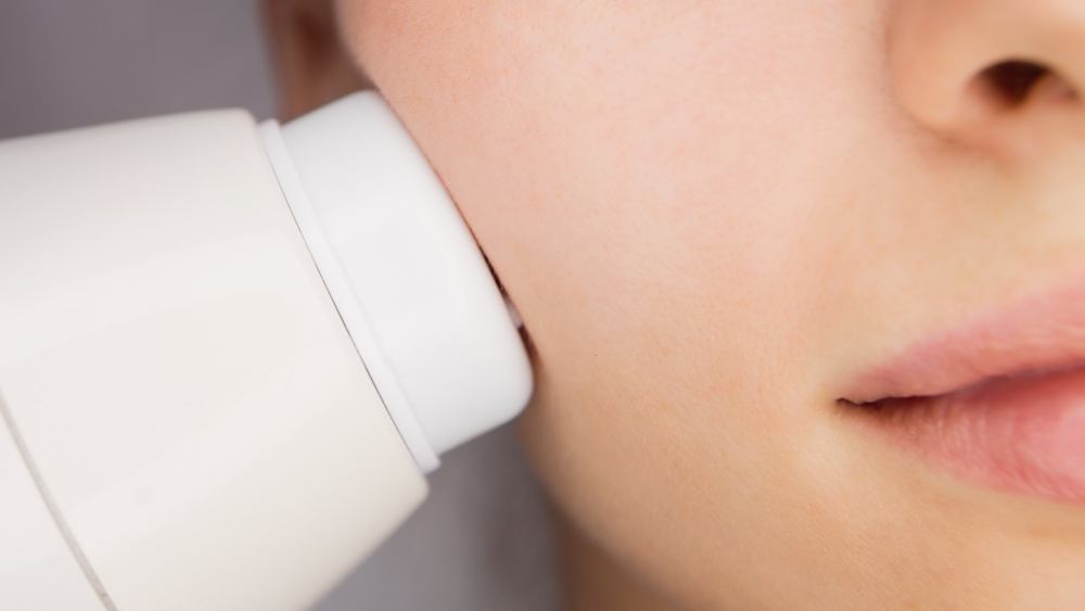 Dermatologist giving facial massage through sonic lifting