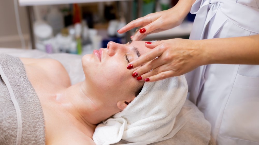 Young woman in a facial spa getting facial massage