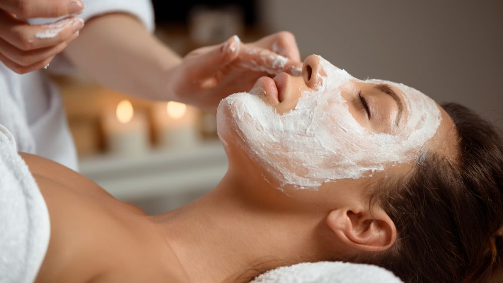 Young woman with mask face in a relaxing spa salon