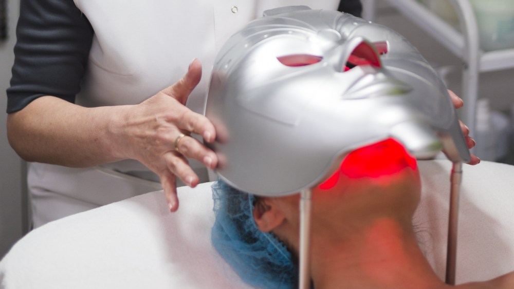 Girl receiving led light therapy treatment in beauty salon